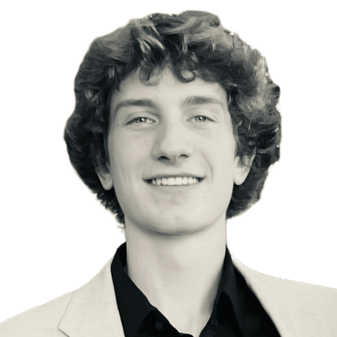 a man wearing a suit and tie smiling at the camera