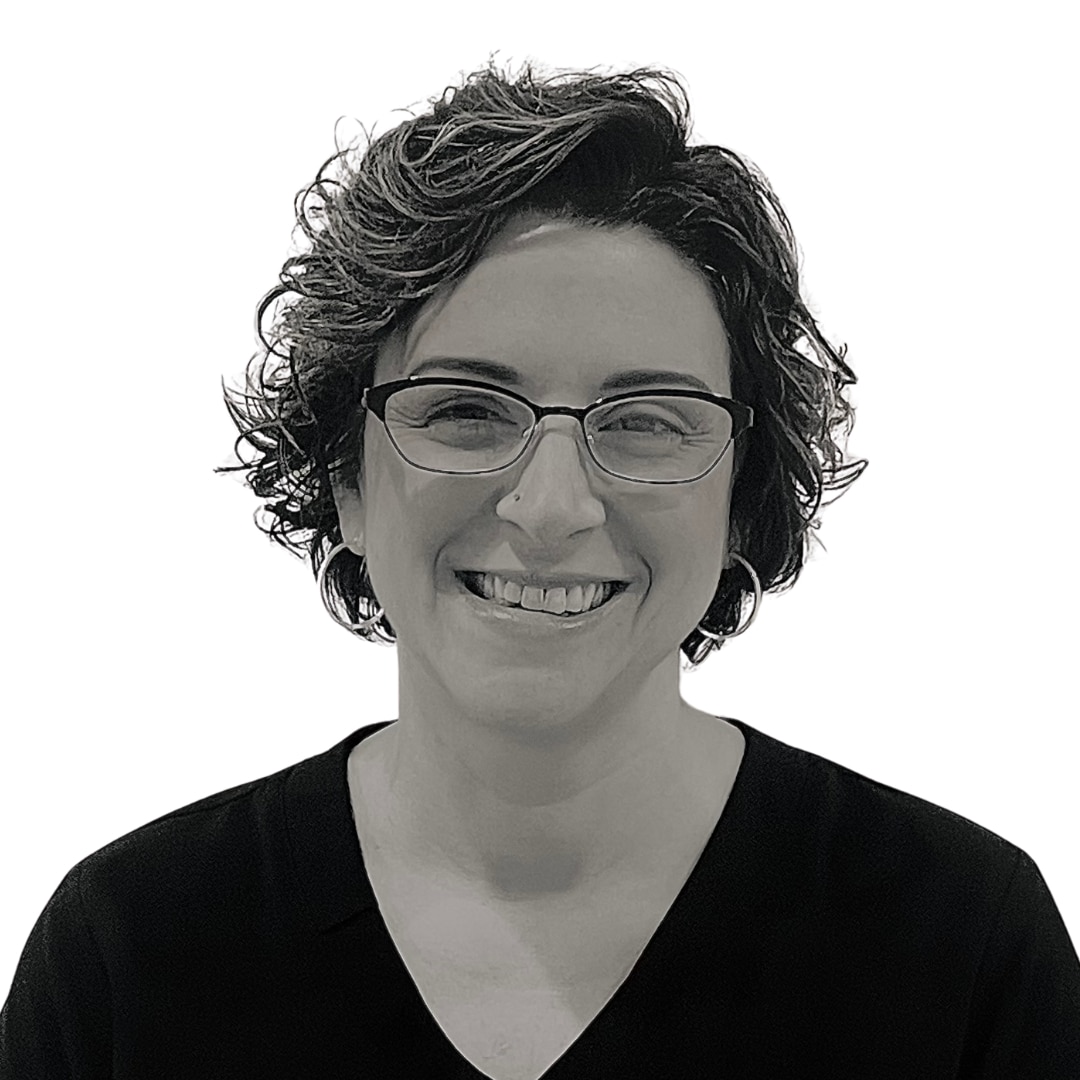 a woman wearing glasses and smiling at the camera