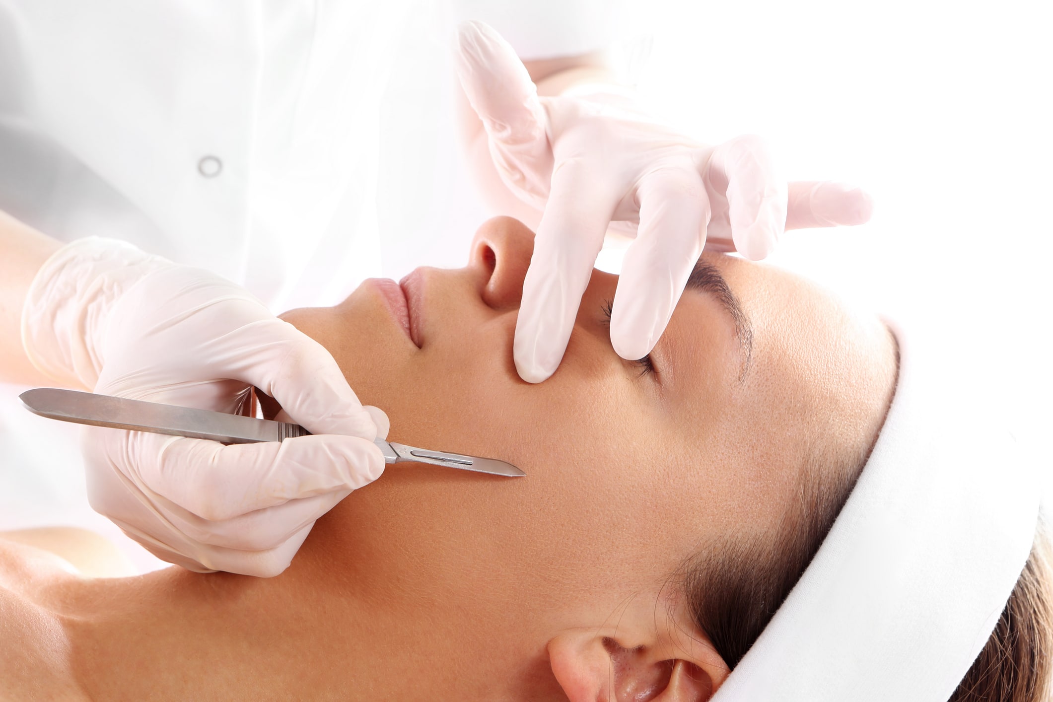 A woman undergoes a gentle and safe dermaplaning treatment at the expert hands of a trained aesthetics professional.